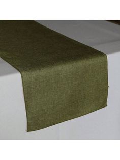 a green table runner on top of a white bed