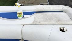 a white and blue boat with a bottle of cleaner on the back end next to it