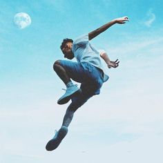 a man flying through the air while riding a skateboard in front of a blue sky