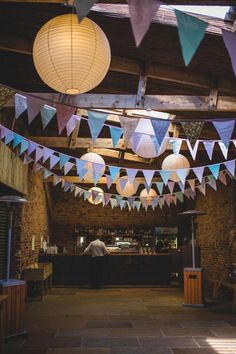 several paper lanterns hanging from the ceiling above a bar