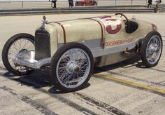 an old fashioned car is parked on the pavement