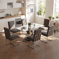 a glass dining table surrounded by grey chairs