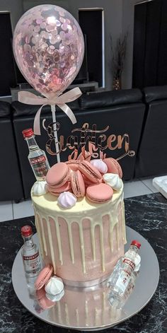 a birthday cake with pink frosting and confetti on top is sitting on a table