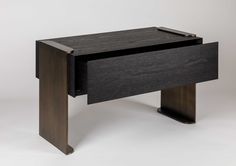 a black desk with an open drawer on it's side, against a white background