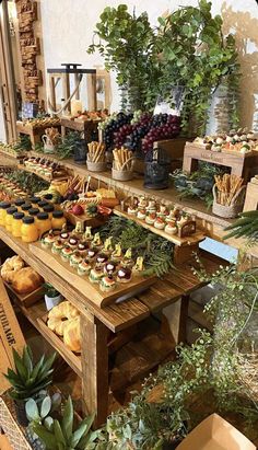 a table filled with lots of different types of food on top of wooden tables next to plants