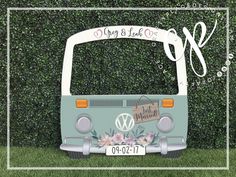 the vw bus is parked in front of a green wall with flowers on it