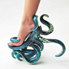 an octopus sculpture is being held by a woman's foot