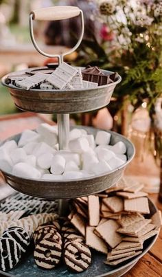 three tiered trays filled with cookies and marshmallows on a table