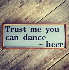 a sign that says trust me, you can dance beer on a wooden table top