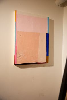 an abstract painting hangs on the wall