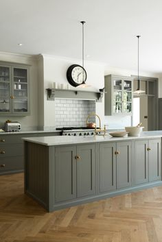 a large kitchen with an island in the middle and cabinets on both sides that are painted gray