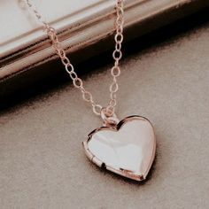 a heart shaped locke necklace sitting on top of a window sill