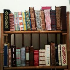 a book shelf filled with lots of books on top of wooden shelves next to a wall