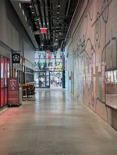 an empty hallway with graffiti on the walls