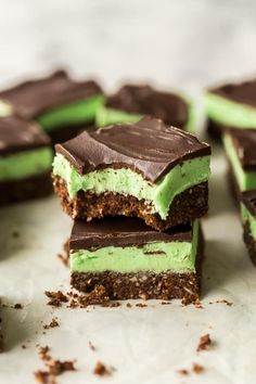 several pieces of green and chocolate dessert sitting on top of each other with one bite taken out