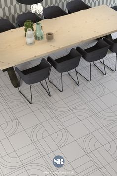 a table with chairs and vases on top of it in front of a patterned wall