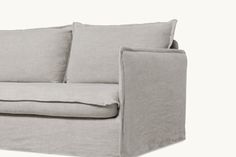 a gray couch with two pillows on it's back and one arm facing the camera