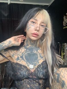 a woman with tattoos on her body and glasses