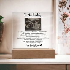 a glass plaque with an image of a baby's feet and the words to my daddy on it