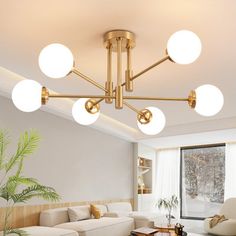 a living room filled with white furniture and lots of lights on top of the ceiling