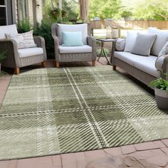 a living room area with couches, chairs and rugs on the ground outside