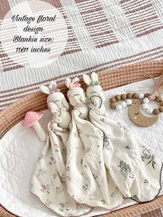 a basket filled with cloths and toys on top of a bed next to a wooden spoon