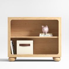 a wooden book shelf with a pig figurine on top