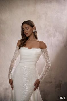 a woman in a white wedding dress posing for a photo with her hands on her hips