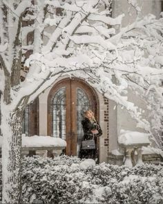 a woman standing in front of a door covered in snow