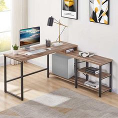 a computer desk with a monitor and keyboard on it next to a rug in front of a window