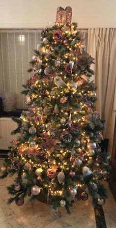 a decorated christmas tree in a living room with lights and ornaments on the bottom half