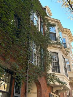 an old building with ivy growing on it's side and windows in the front