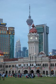 a large building with a clock tower in the middle of it's center surrounded by tall buildings