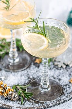 two glasses filled with lemonade and rosemary garnish on top of a tray