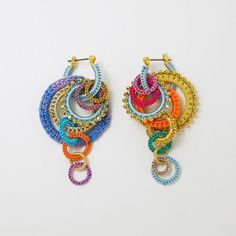 two pairs of multicolored beaded hoop earrings on white background with clippings