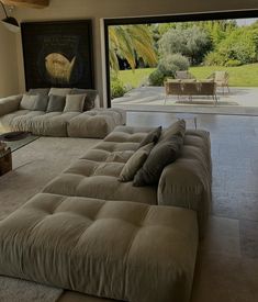 a living room filled with lots of furniture and large glass doors leading to an outside patio