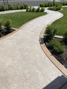 an empty sidewalk in the middle of a park