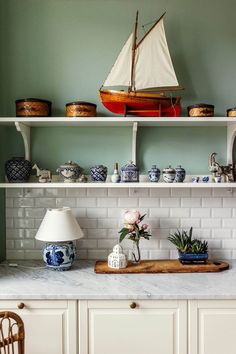 a sailboat on top of a shelf in a kitchen