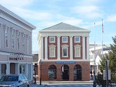 an old brick building on the corner of a street with cars parked in front of it