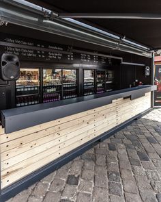 an outdoor bar with sound equipment on the outside and brick pavement in front of it