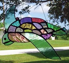 a stained glass turtle hanging from a tree