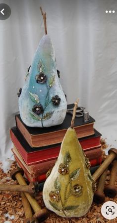 two pears sitting on top of each other next to some books and cinnamon sticks