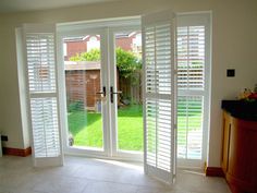 an open patio door with shutters on both sides and sliding glass doors to the outside