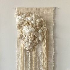 a white wall hanging with flowers on it