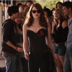 a woman in a corset and sunglasses standing next to a group of people