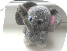 a gray stuffed animal sitting on top of a window sill