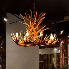 a chandelier made out of deer antlers hangs from the ceiling in a dining room