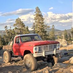 a red truck driving down a rocky road