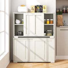 a kitchen with white cabinets and wooden floors