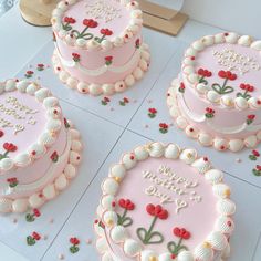 four pink birthday cakes sitting on top of a table